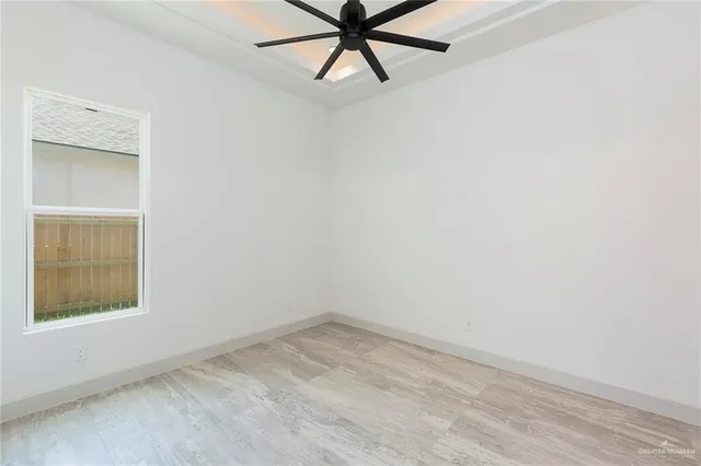 an empty room with a window and a fan