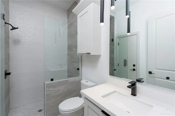 a bathroom with a sink a toilet and shower