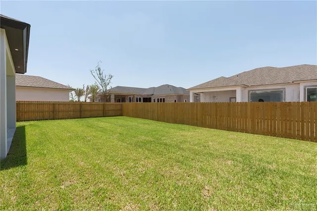 a view of an house with backyard and a tree