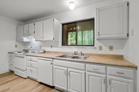 a kitchen with granite countertop a sink and a refrigerator