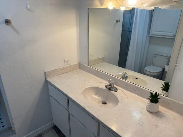 a white toilet sitting next to a shower