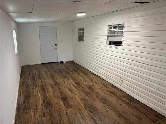 a view of a small house with a door and wooden fence