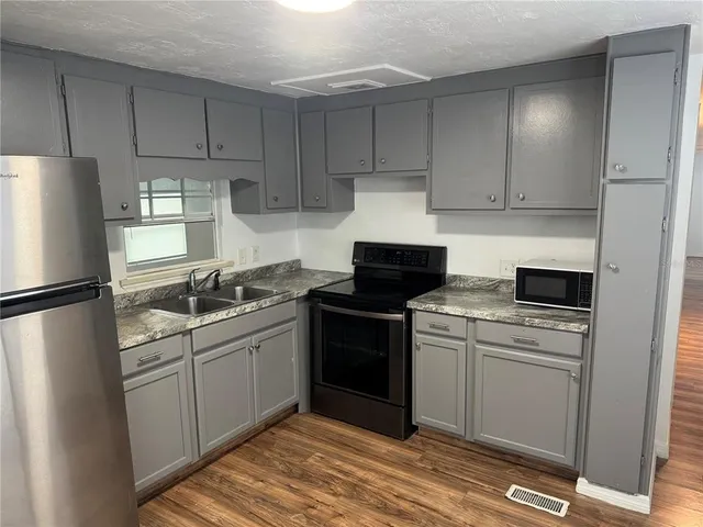 a kitchen with a sink a refrigerator and cabinets