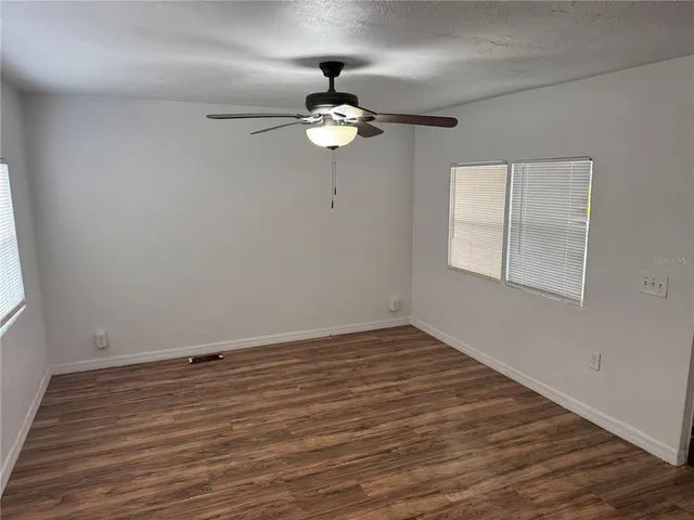a view of a room with wooden floor and a window