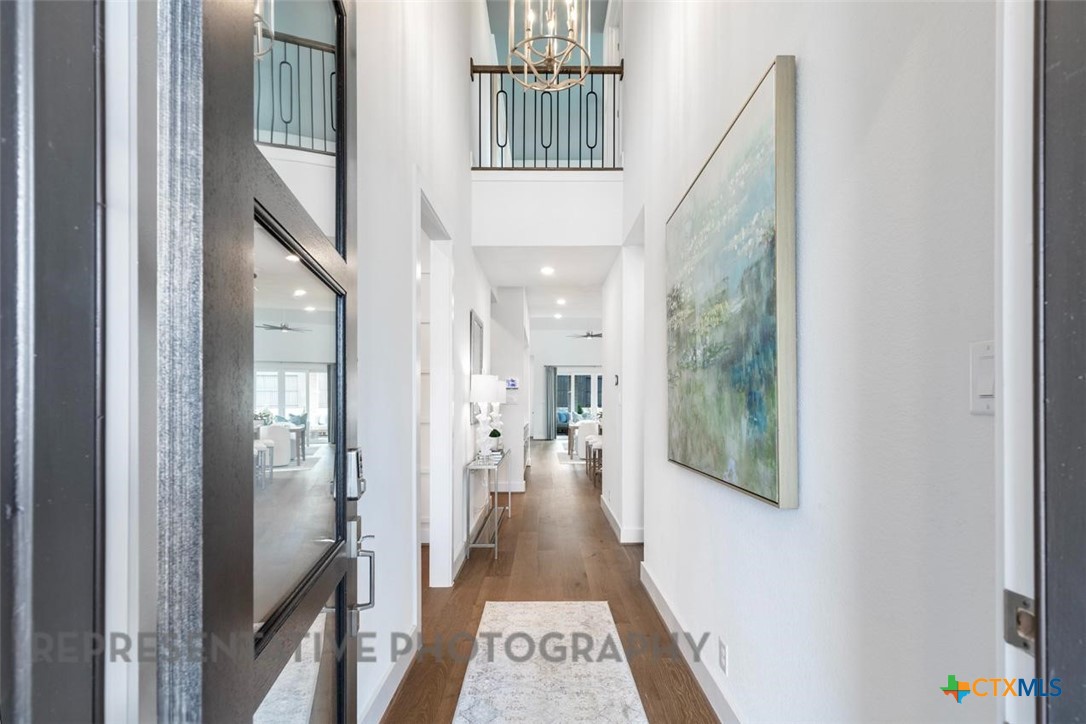 608 High Summit Drive Georgetown, TX 78628 - Photo 17 of 36 a view of hallway with wooden floor and a chandelier
