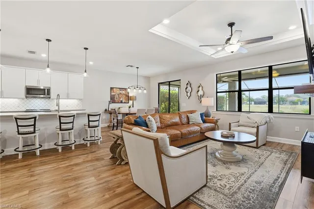 a living room with furniture kitchen view and a chandelier