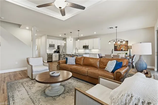 a kitchen with stainless steel appliances granite countertop a stove top oven a sink a dining table and chairs with wooden floor