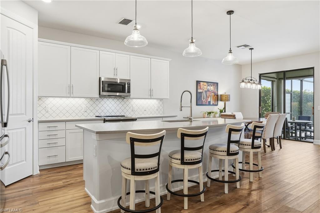 19906 Beverly Park Road Estero, FL 33928 - Photo 17 of 50 a kitchen with sink cabinets and wooden floor