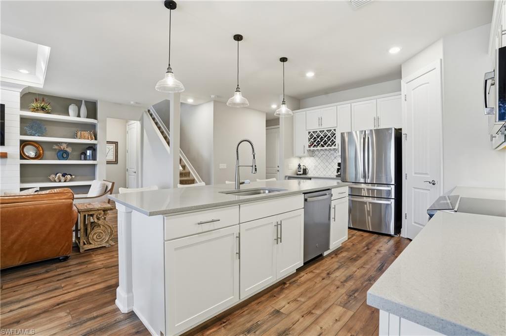 19906 Beverly Park Road Estero, FL 33928 - Photo 21 of 50 a kitchen with stainless steel appliances granite countertop a sink a stove a refrigerator and island with wooden floor