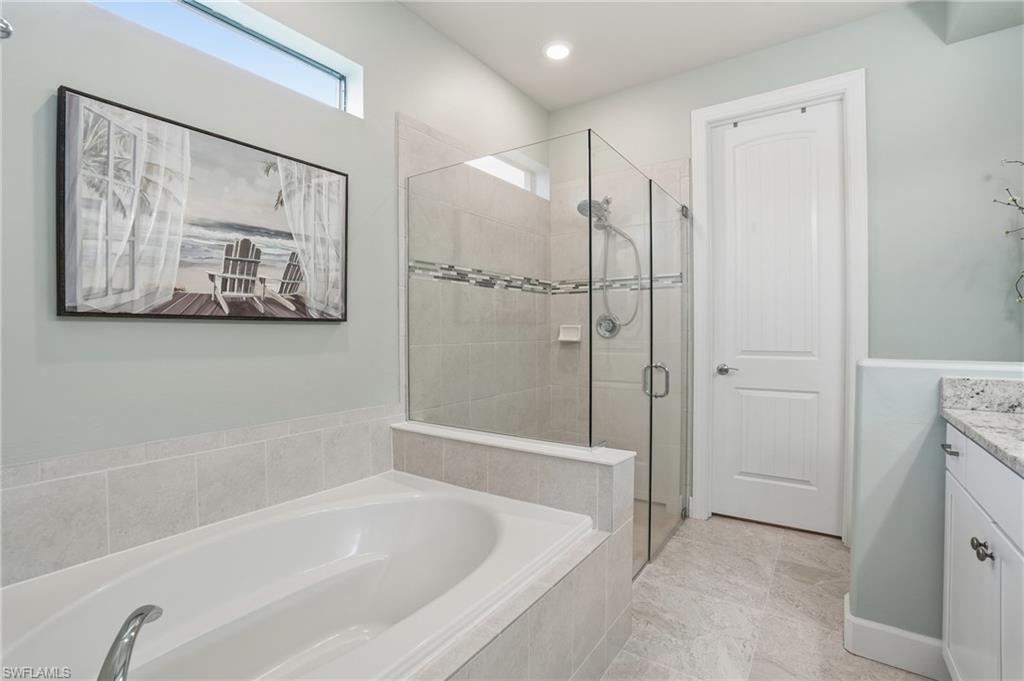 19906 Beverly Park Road Estero, FL 33928 - Photo 31 of 50 a bathroom with a bathtub and a shower