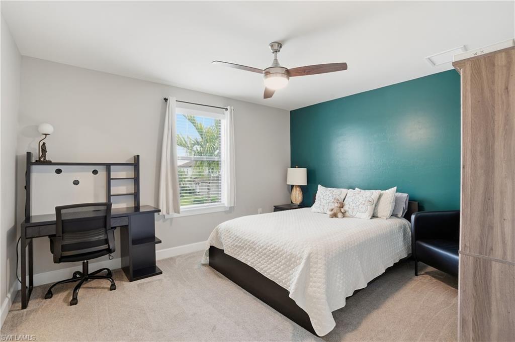 19906 Beverly Park Road Estero, FL 33928 - Photo 34 of 50 a bedroom with a large bed and a chandelier