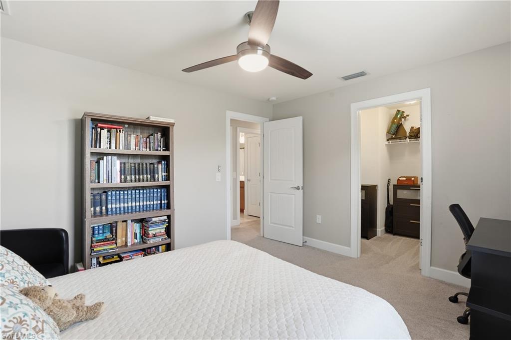 19906 Beverly Park Road Estero, FL 33928 - Photo 35 of 50 a bedroom with a bed and a book shelf