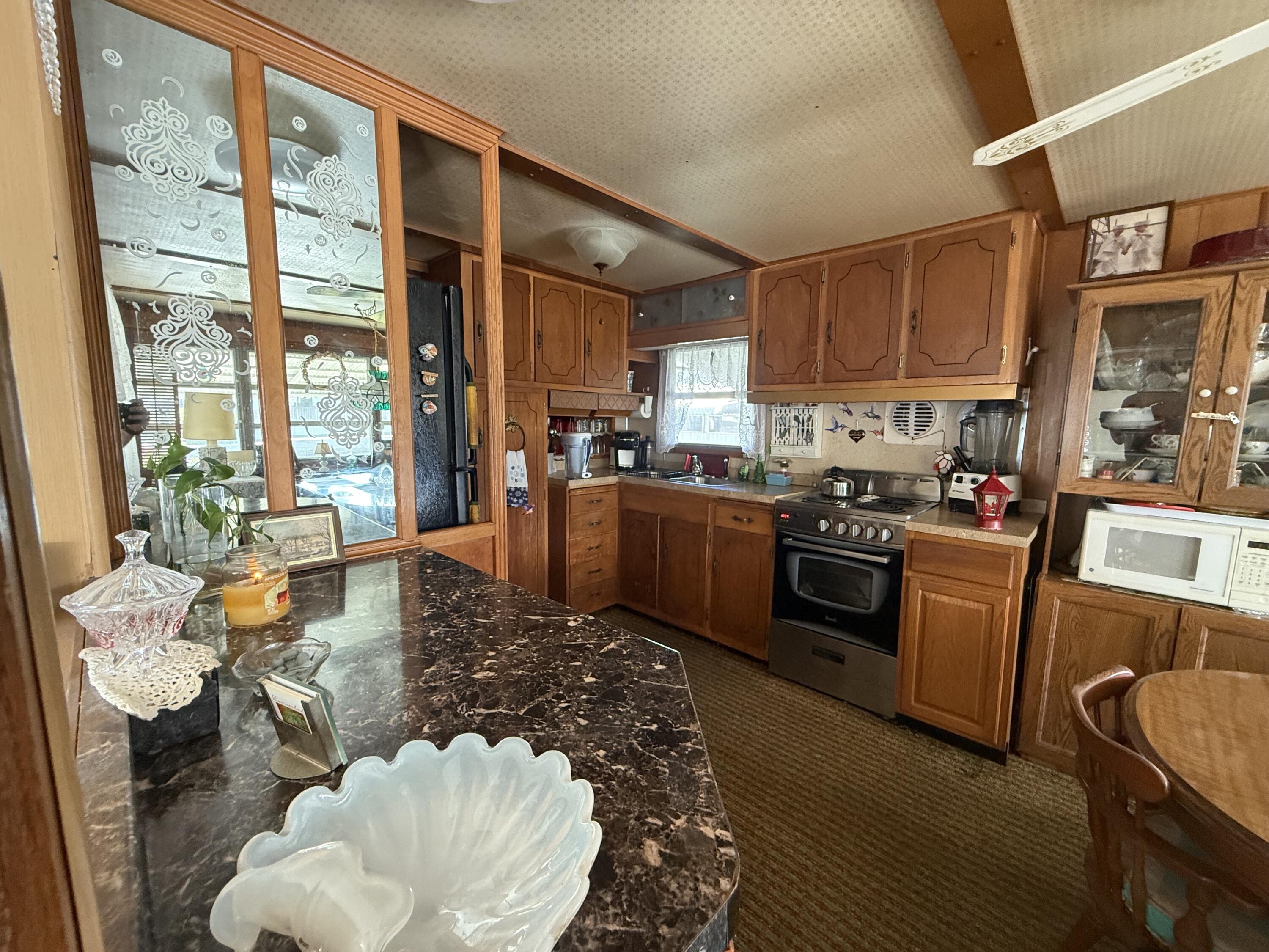 203 South Ibis Drive, Unit R Briny Breezes, FL 33435 - Photo 19 of 24 a kitchen with a table chairs stove and kitchen view