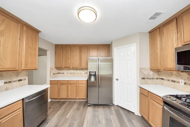 a kitchen with a sink cabinets stainless steel appliances and a window