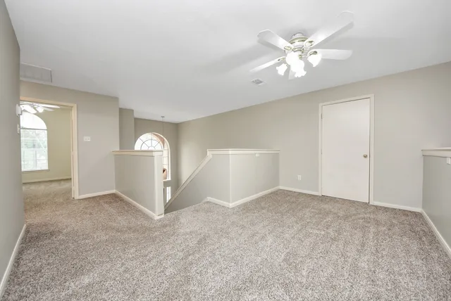 an empty room with fan and windows