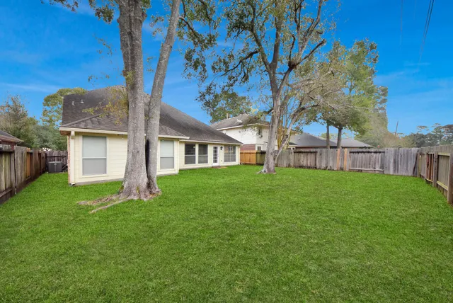 a view of a house with backyard and a tree