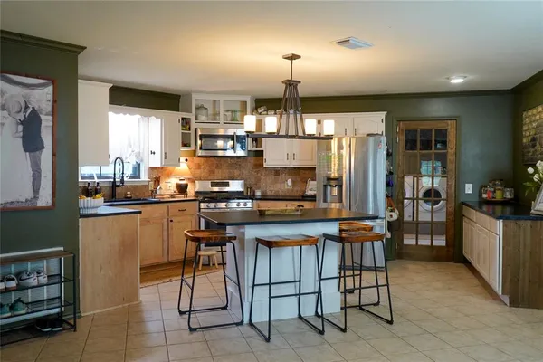 a kitchen with kitchen island granite countertop lots of counter top space and stainless steel appliances