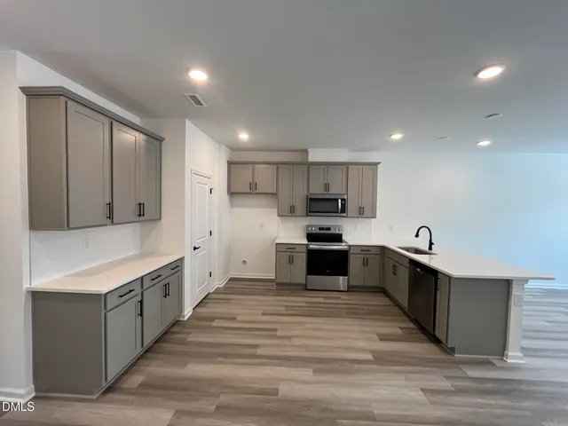 a large kitchen with stainless steel appliances and a sink