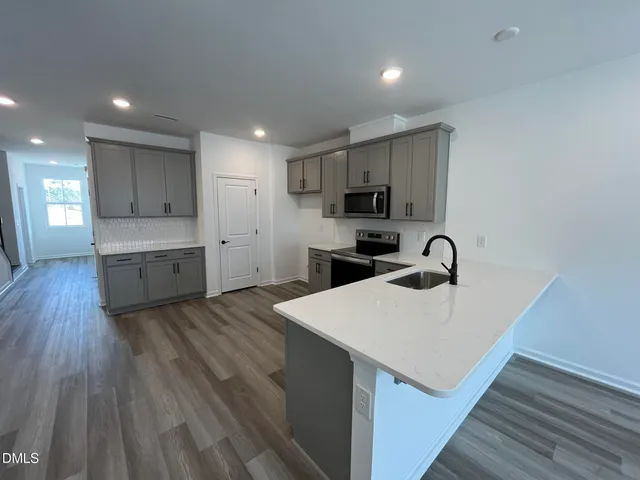 a kitchen with a sink a stove a refrigerator and a microwave