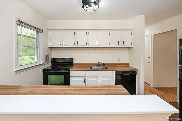 a kitchen with stainless steel appliances granite countertop a stove and a white cabinets