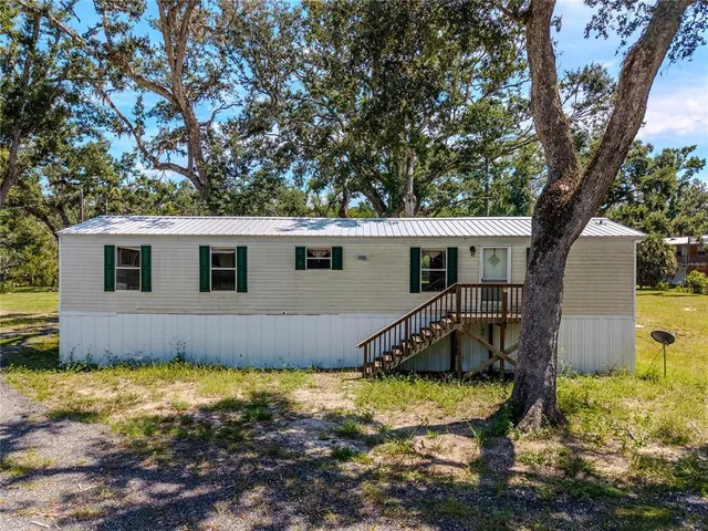a view of a house with backyard and tree