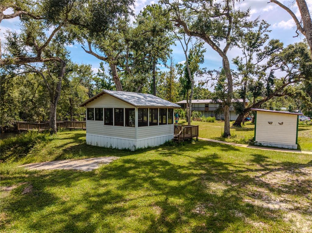 2008 River Road Steinhatchee, FL 32359 - Photo 20 of 41 a white house with a large tree next to a yard with large trees
