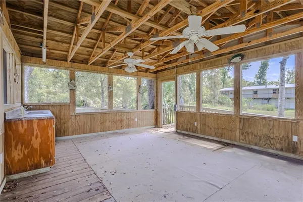 a room with a walk in closet a mirror and cabinets