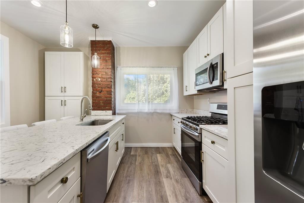 22 Millbridge Street Pittsburgh, PA 15210 - Photo 13 of 25 a kitchen with granite countertop a sink a counter space appliances and cabinets
