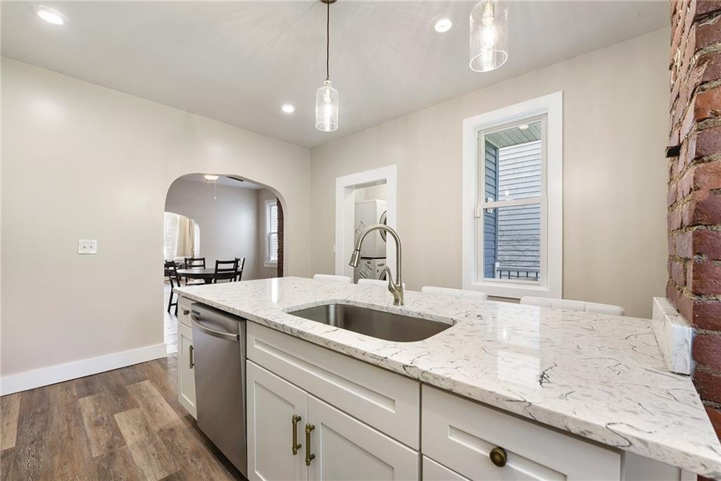 22 Millbridge Street Pittsburgh, PA 15210 - Photo 14 of 25 a kitchen with a sink and a stove with wooden floor