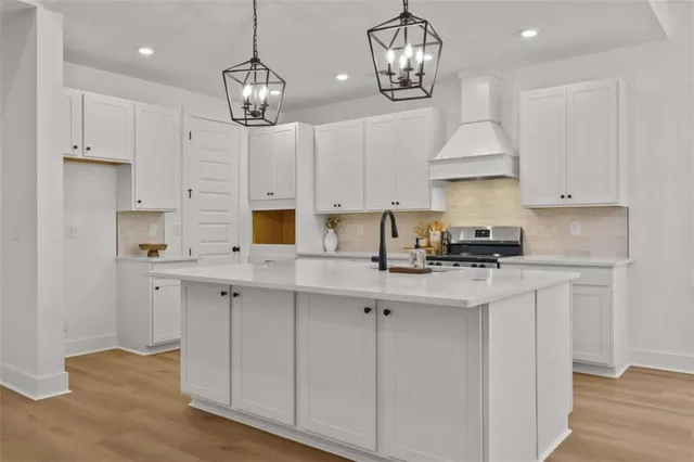 a kitchen with stainless steel appliances kitchen island a large island in the center and wooden floor