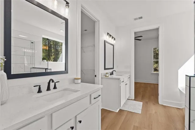 a living room with furniture and kitchen view with wooden floor
