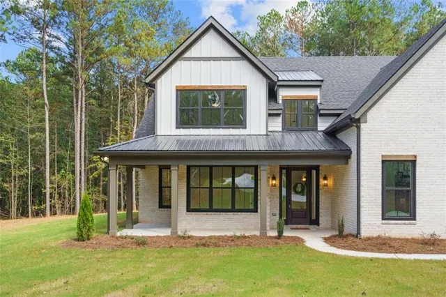 a view of a brick house with large windows and a large tree