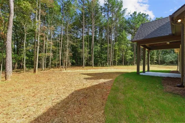 a front view of a house with a yard and trees