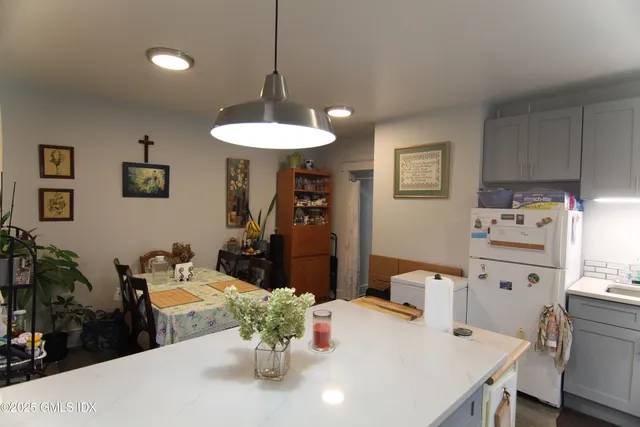 a kitchen with stainless steel appliances a table and chairs in it