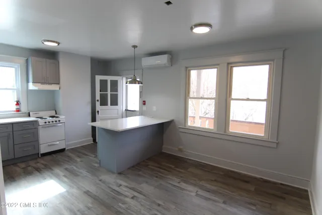 a large kitchen with kitchen island wooden floors and stainless steel appliances