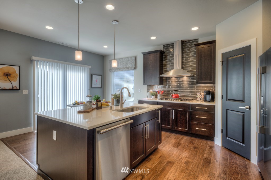 4130 227th Street Southeast, Unit 36 Bothell, WA 98021 - Photo 8 of 25 a kitchen with kitchen island granite countertop a sink appliances and cabinets