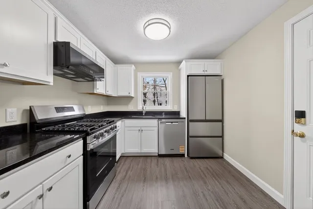 a kitchen with a refrigerator stove and wooden cabinets