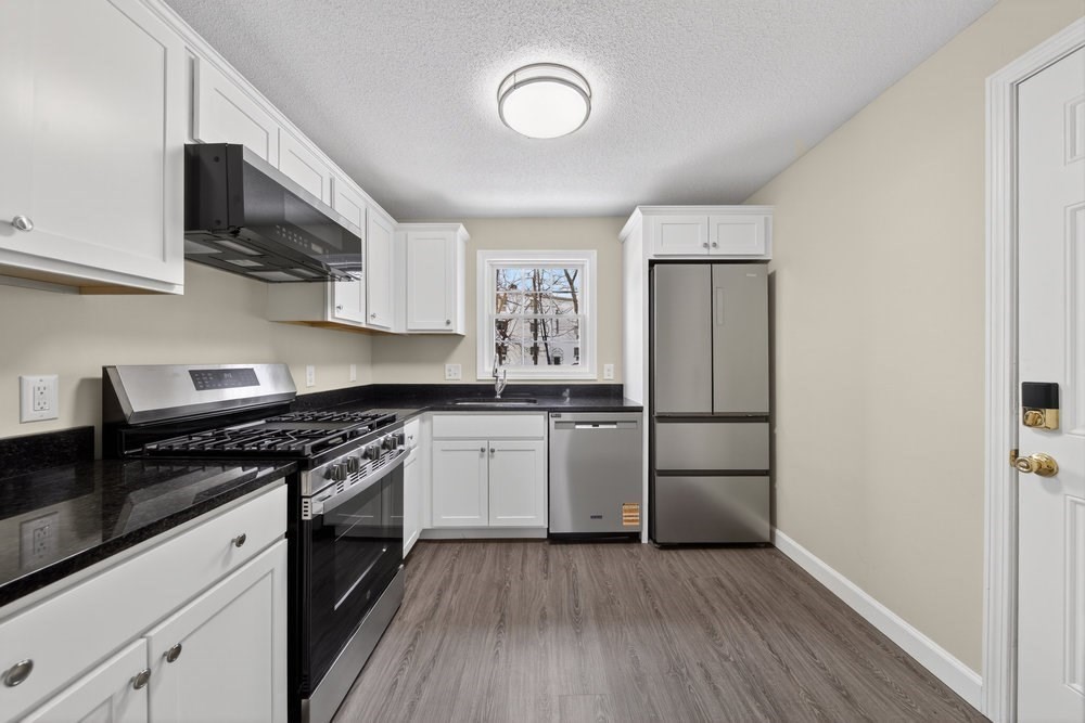 508 Cold Spring Avenue, Unit 1A West Springfield, MA 01089 - Photo 3 of 27 a kitchen with a refrigerator stove and wooden cabinets