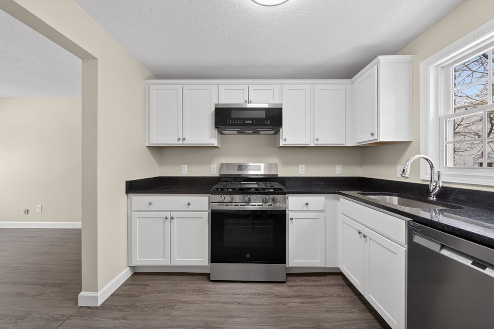 508 Cold Spring Avenue, Unit 1A West Springfield, MA 01089 - Photo 4 of 27 a kitchen with stainless steel appliances granite countertop a stove and white cabinets