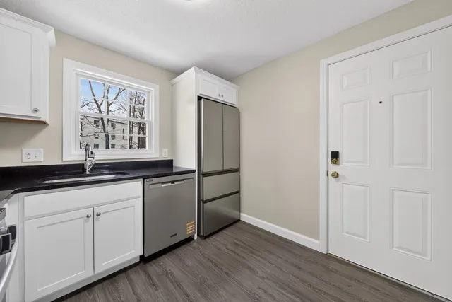 a kitchen with granite countertop white cabinets and white appliances