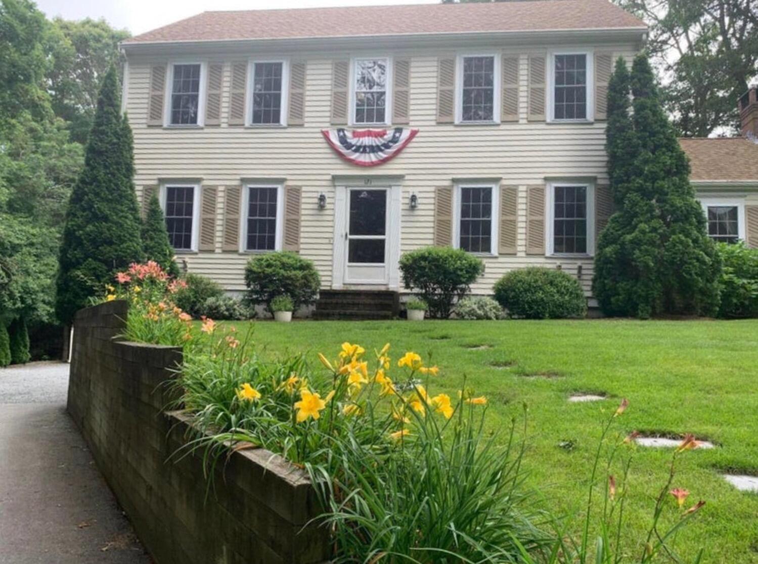 a front view of a house with a yard and potted plants