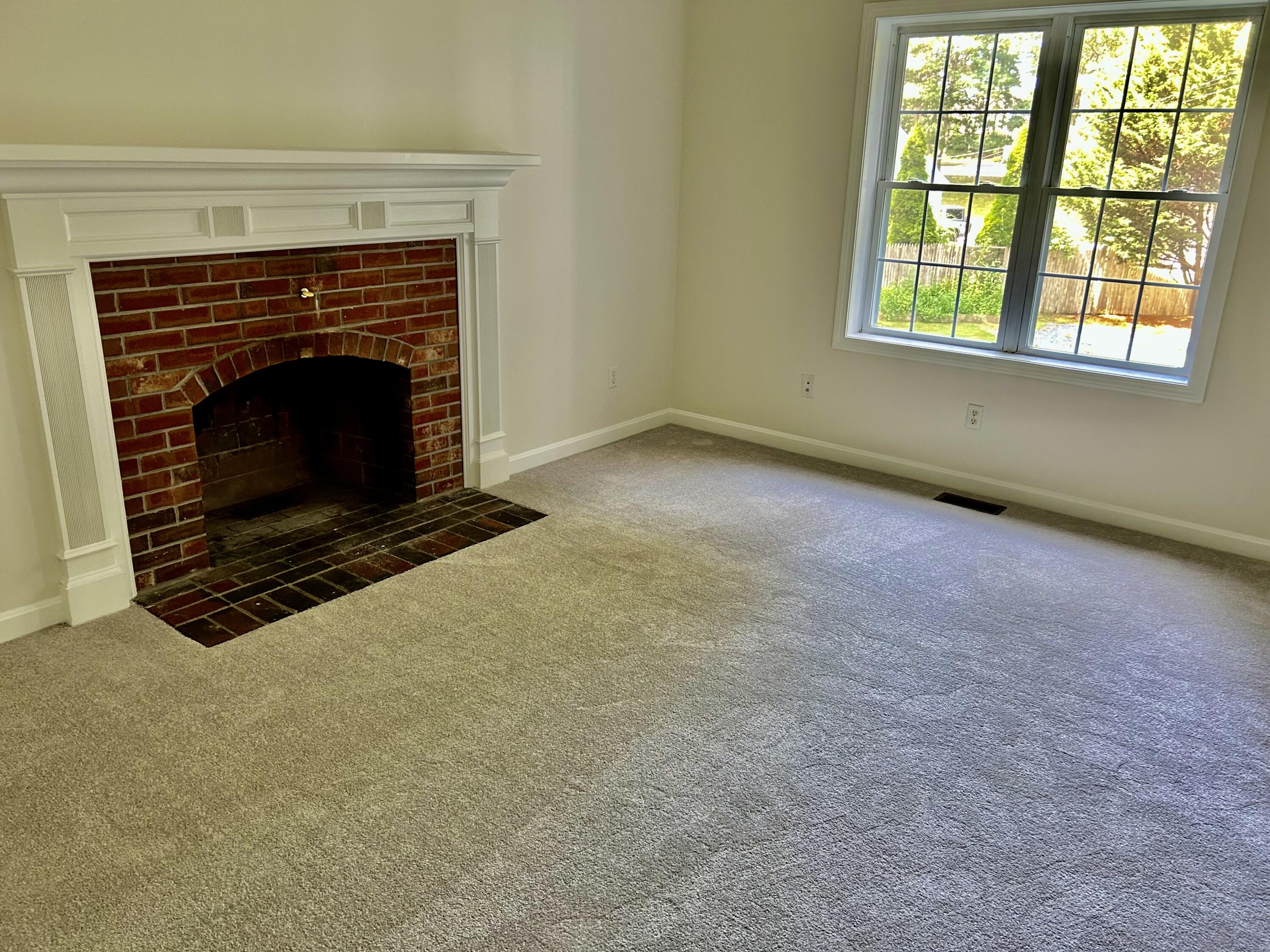 121 Old Post Road Centerville, MA 02632 - Photo 9 of 39 an empty room with a fireplace and a window