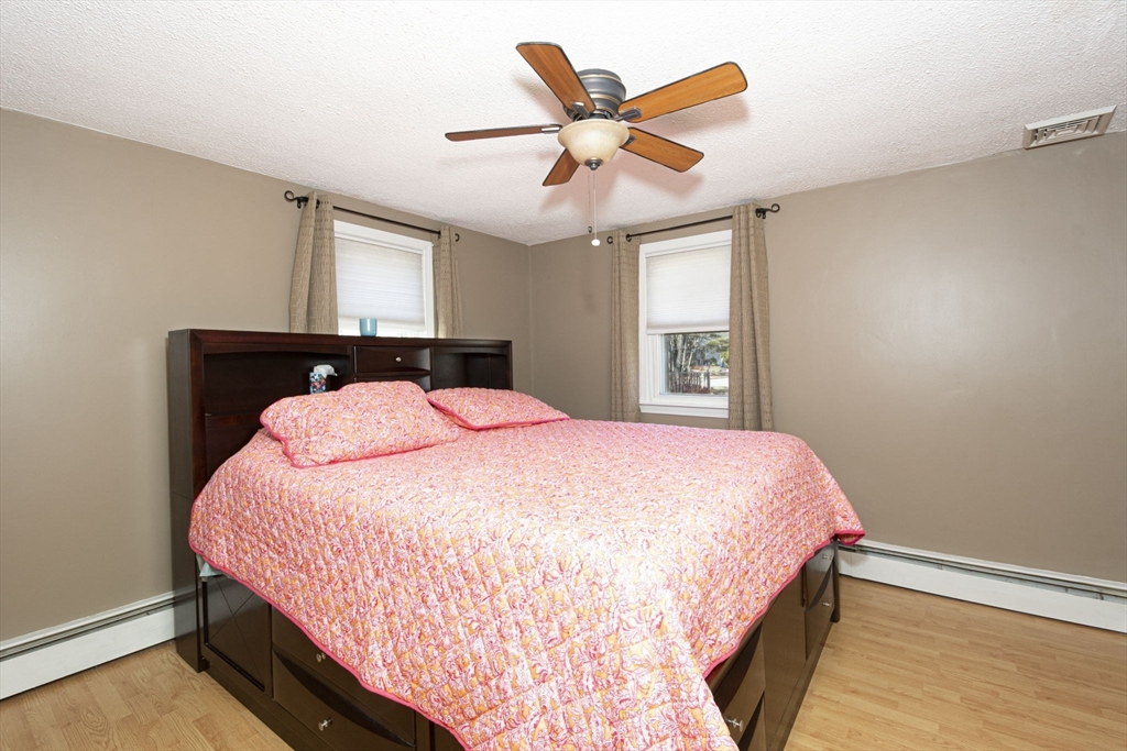 29 Reo Road Maynard, MA 01754 - Photo 22 of 23 a bedroom with a large bed and a chandelier