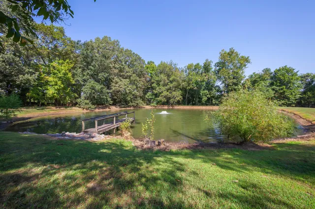 a view of a house with a yard and a fountain