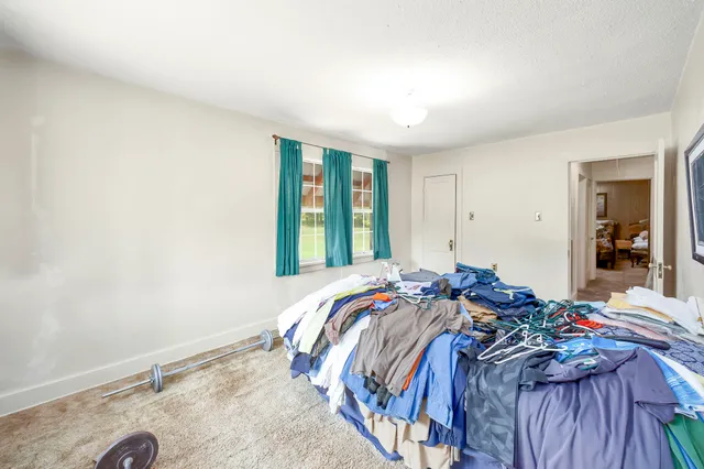 a bed sitting in a bedroom next to a window