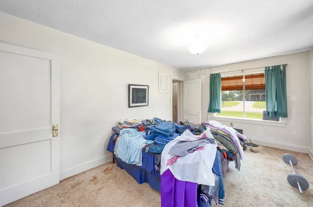 a bed sitting in a bedroom next to a window