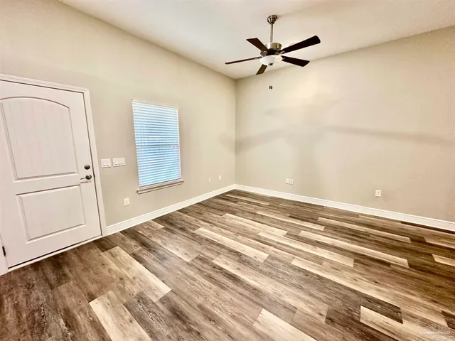 a view of a livingroom with a ceiling fan and wooden floor