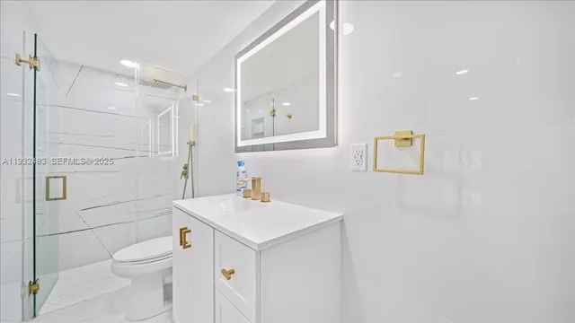 a bathroom with a toilet a sink a mirror and vanity