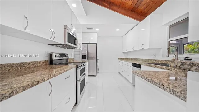 a kitchen with stainless steel appliances granite countertop a sink stove and refrigerator