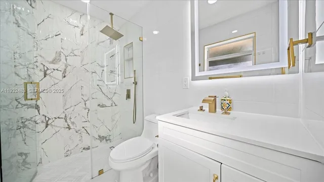 a bathroom with a granite countertop sink and a toilet